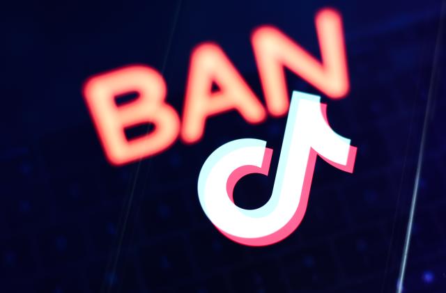 Ban sign displayed on a laptop screen and TikTok logo displayed on a phone screen are seen in this multiple exposure illustration photo taken in Krakow, Poland on March 27, 2023. (Photo by Jakub Porzycki/NurPhoto via Getty Images)