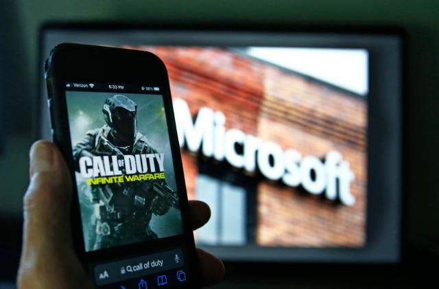 ARCHIVO - Imagen del juego Call of Duty de Activision vista en un teléfono celular cerca de una foto del logo de Microsoft en Nueva York, 15 de junio de 2023. 