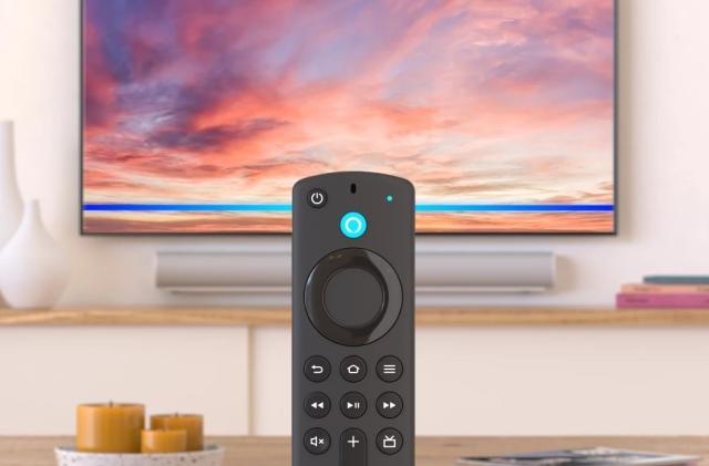 The Alexa Voice Remote included with Amazon's Fire TV 4K Max media streamer is shown in a living room in front of a TV and soundbar.