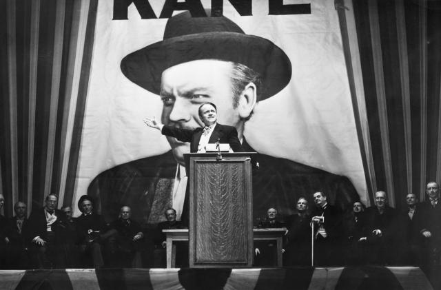 Charles Foster Kane (Orson Welles) makes a stirring campaign speech before a larger-than-life portrait of himself in a scene from Citizen Kane.